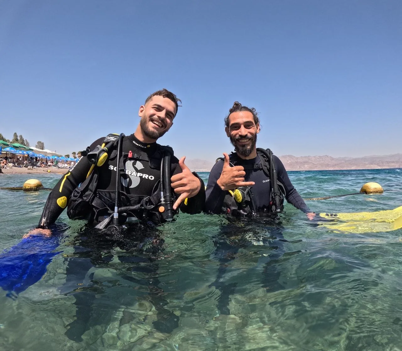 שני צוללים מחייכים עומדים בים האדום
